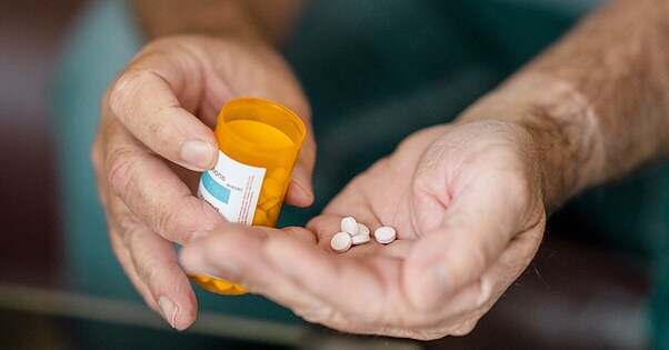 Male senior Bromazepam pills in hand