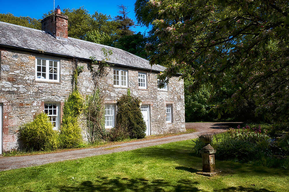 Picturesque stone cottage rehab center in rural Wales surrounded by lush greenery and trees